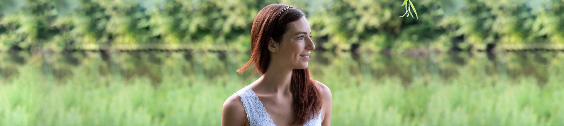 profiel van het hoofd van een lachend meisje met bruin haar in de natuur. foto door Bloom Photography